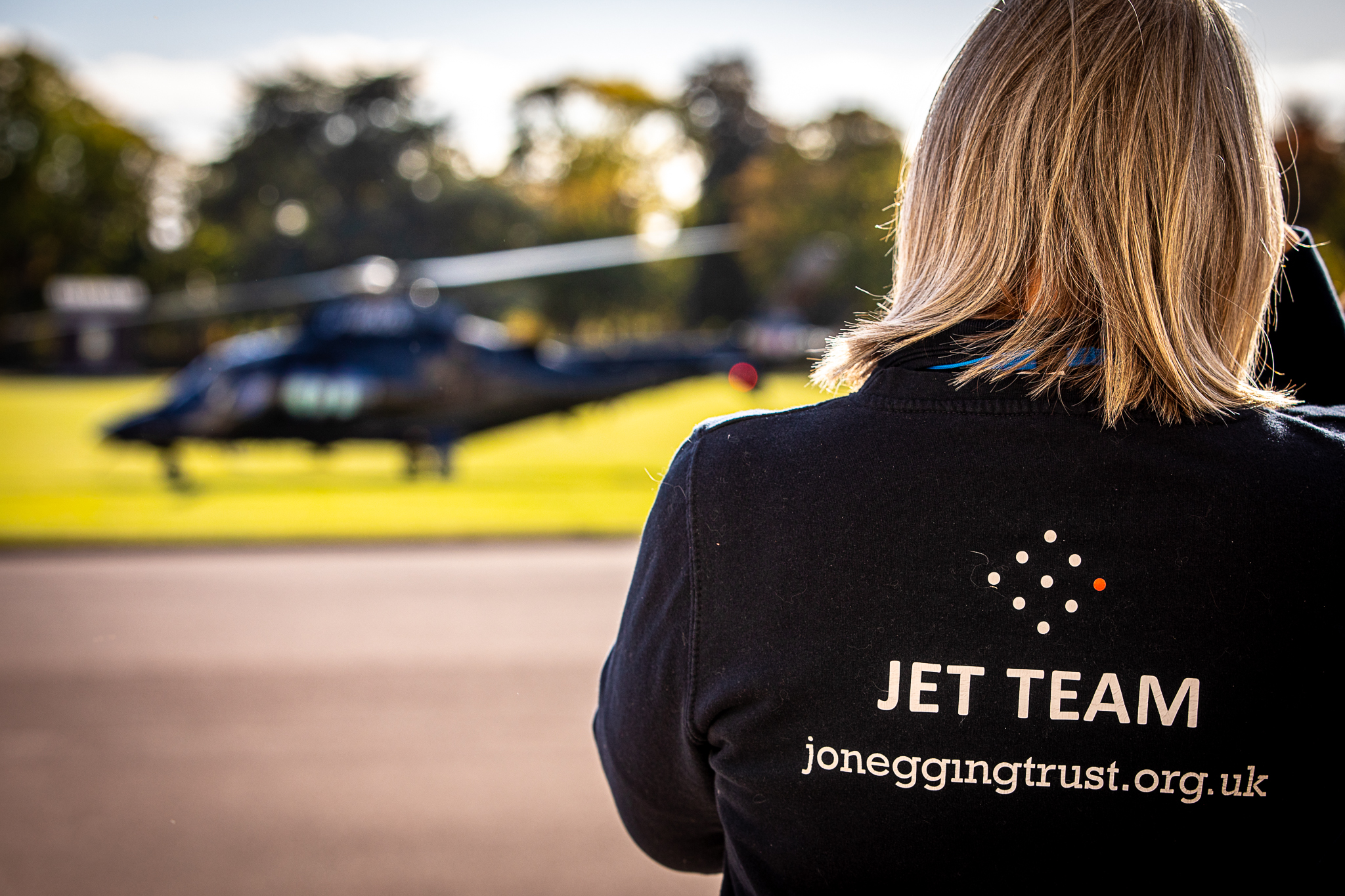 Image shows member of the JET team looking towards a helicopter.